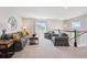 Comfortable bonus room featuring soft carpet, a seating arrangement, and natural light from multiple windows at 16268 Mount Silverheels Way, Broomfield, CO 80023