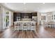 Modern kitchen featuring a center island, stainless steel appliances, dark cabinets, and a dining area at 16268 Mount Silverheels Way, Broomfield, CO 80023