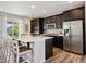 Modern kitchen featuring a center island, stainless steel appliances, dark cabinets, and a stylish backsplash at 16268 Mount Silverheels Way, Broomfield, CO 80023