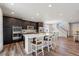 Spacious kitchen with a center island, stainless steel appliances, dark wood cabinets, and a dining area at 16268 Mount Silverheels Way, Broomfield, CO 80023