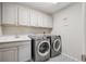 Well-organized laundry room boasts modern appliances, ample cabinet space, and stylish flooring at 16268 Mount Silverheels Way, Broomfield, CO 80023