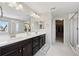 Elegant main bathroom with double vanity, a walk-in shower, and a doorway to a walk-in closet at 16268 Mount Silverheels Way, Broomfield, CO 80023