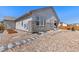 Backyard with gravel landscaping, a stone patio, and garden beds at 24447 E Ada Ave, Aurora, CO 80018