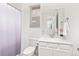 Clean, bright bathroom featuring white marble countertop, toilet, decorative orchid, and a shower with an ombre curtain at 24447 E Ada Ave, Aurora, CO 80018