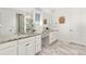 Double vanity in the bathroom featuring white cabinets, granite countertops, and framed mirrors at 24447 E Ada Ave, Aurora, CO 80018