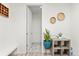 Bright entryway with light wood floors, white walls, and decorative accents, and a door leading to a tiled area at 24447 E Ada Ave, Aurora, CO 80018
