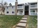 Traditional-style condo building with an exterior balcony and landscaped yard at 14493 E Jewell Ave # 102, Aurora, CO 80012