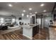 Open-concept kitchen features large island with granite countertops and dark cabinetry, seamlessly connecting to the living room at 4025 Trail Stone Cir, Castle Rock, CO 80108