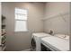 Laundry room featuring modern washer and dryer, ample shelf storage, and natural light at 4025 Trail Stone Cir, Castle Rock, CO 80108