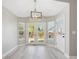 Dining area with hardwood floors, large windows, a modern light fixture, and access to the backyard at 765 Freestone St, Brighton, CO 80603