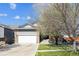 Charming home with a stone facade, attached two-car garage, and a well-maintained front yard at 765 Freestone St, Brighton, CO 80603