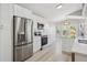 Updated kitchen with stainless steel refrigerator and range, white cabinets and subway tile backsplash at 765 Freestone St, Brighton, CO 80603