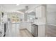 Bright kitchen featuring white cabinetry, stainless steel appliances, and hardwood floors at 765 Freestone St, Brighton, CO 80603