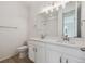 A bright bathroom has a double vanity with white cabinetry and brushed metal hardware at 1306 Sienna Peak Cir, Erie, CO 80516