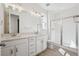 A modern bathroom features a double vanity, a shower with glass doors and wood-look floors at 1306 Sienna Peak Cir, Erie, CO 80516
