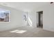 This carpeted bedroom has two windows and an open doorway to another room at 1306 Sienna Peak Cir, Erie, CO 80516