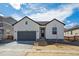 Charming single-Gathering home with gray garage door, contrasting trim, and minimal landscaping at 1306 Sienna Peak Cir, Erie, CO 80516
