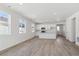 Open-concept living space with kitchen featuring white cabinets, an island, and wood floors at 1306 Sienna Peak Cir, Erie, CO 80516