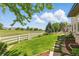Serene backyard featuring lush green grass, a white fence, and mature trees providing picturesque views with a stone path at 4405 Fairway Ln, Broomfield, CO 80023