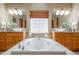 Elegant bathroom features a large soaking tub, double sinks with modern lighting, and a decorative glass block window at 4405 Fairway Ln, Broomfield, CO 80023