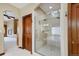 Modern bathroom features a glass shower, a soaking tub, updated fixtures, and an entrance to the main bedroom at 4405 Fairway Ln, Broomfield, CO 80023