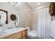 Well-lit bathroom with a large mirror, neutral tile, and a shower-tub combo at 4405 Fairway Ln, Broomfield, CO 80023