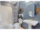 Updated bathroom featuring a stylish pedestal sink, oval mirror, and shower-tub combo at 4405 Fairway Ln, Broomfield, CO 80023