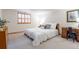 Bright bedroom featuring a comfortable bed with decorative pillows and a wooden writing desk adjacent to shuttered window at 4405 Fairway Ln, Broomfield, CO 80023