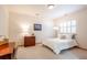 Inviting bedroom featuring a bed with soft white bedding, shuttered window, and dark wood writing desk and cabinet at 4405 Fairway Ln, Broomfield, CO 80023