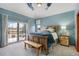 Bright bedroom with cozy carpeting, a ceiling fan, a bench seat, and a sliding glass door leading to the patio at 4405 Fairway Ln, Broomfield, CO 80023