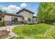 Beautiful home exterior with lush green lawn and stone accents, patio, and views of mature trees on a sunny day at 4405 Fairway Ln, Broomfield, CO 80023
