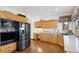 Functional kitchen featuring natural wood cabinets, granite countertops, and modern appliances at 4405 Fairway Ln, Broomfield, CO 80023