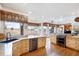 Gourmet kitchen featuring natural wood cabinets, granite countertops, and stainless steel appliances at 4405 Fairway Ln, Broomfield, CO 80023