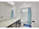 Bathroom with shower and bathtub, blue shower curtain, and ample counter space at 4996 Cathay Ct, Denver, CO 80249