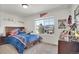 Bedroom with a large window, a dresser, and a sports themed bedspread at 4996 Cathay Ct, Denver, CO 80249