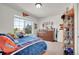 Bedroom featuring a large window, a dresser, shelving, and lots of personal memorabilia at 4996 Cathay Ct, Denver, CO 80249