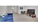Cozy living room area with carpet, a blue sofa, a TV, and a table with chairs at 4996 Cathay Ct, Denver, CO 80249