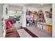 Open floor plan with a playroom, featuring carpeted floors, a view to the living room with hardwood floors at 4996 Cathay Ct, Denver, CO 80249