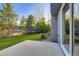 Lush backyard with a patio, tall trees, shrubs, and a trampoline providing ample space for outdoor activities at 5645 S Himalaya Way, Centennial, CO 80015