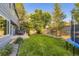 A spacious backyard with a trampoline, outdoor seating, and mature trees, perfect for relaxation and entertainment at 5645 S Himalaya Way, Centennial, CO 80015