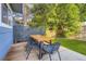 Cozy backyard features an outdoor dining set on a wooden deck, surrounded by mature trees and lush greenery at 5645 S Himalaya Way, Centennial, CO 80015