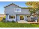 Back exterior of a home featuring a well-maintained lawn, patio, mature trees, and classic siding at 5645 S Himalaya Way, Centennial, CO 80015