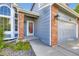 Home featuring a red front door, brick accents, blue siding, and manicured landscaping at 5645 S Himalaya Way, Centennial, CO 80015