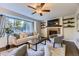 Comfortable living room with fireplace, built-in shelves, and a large window with backyard view at 5645 S Himalaya Way, Centennial, CO 80015