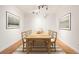 Bright dining room with wood table and six chairs under modern lighting at 695 S Alton Way # 9C, Denver, CO 80247