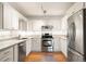 Well-lit kitchen featuring stainless steel appliances, white cabinets, and granite countertops at 695 S Alton Way # 9C, Denver, CO 80247