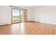 Bright living room features a balcony, wood floors, and shuttered windows at 695 S Alton Way # 9C, Denver, CO 80247