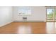 Bright living room features a balcony, wood floors, and shuttered windows at 695 S Alton Way # 9C, Denver, CO 80247