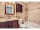 Well-kept bathroom featuring a tub, tile surround, vanity, and dark wood storage at 6233 W 75Th Ave, Arvada, CO 80003