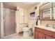 Cozy bathroom featuring a shower, toilet, vanity, and built in cabinet for convenient storage at 6233 W 75Th Ave, Arvada, CO 80003